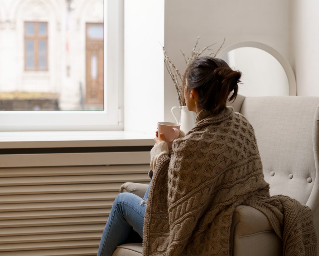woman sitting in front of her window on a winter day
